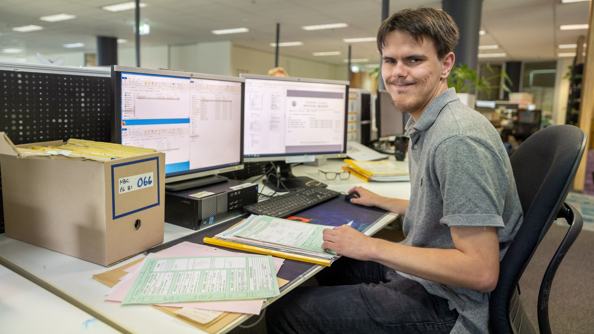 Jigsaw trainee is sitting at a desk in front of two monitors.